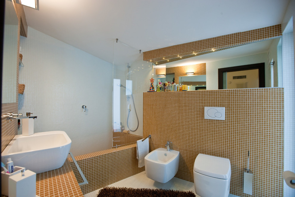 Diseño de cuarto de baño principal actual de tamaño medio con bañera empotrada, combinación de ducha y bañera, sanitario de pared, baldosas y/o azulejos en mosaico, paredes blancas, suelo con mosaicos de baldosas, lavabo sobreencimera y ducha abierta