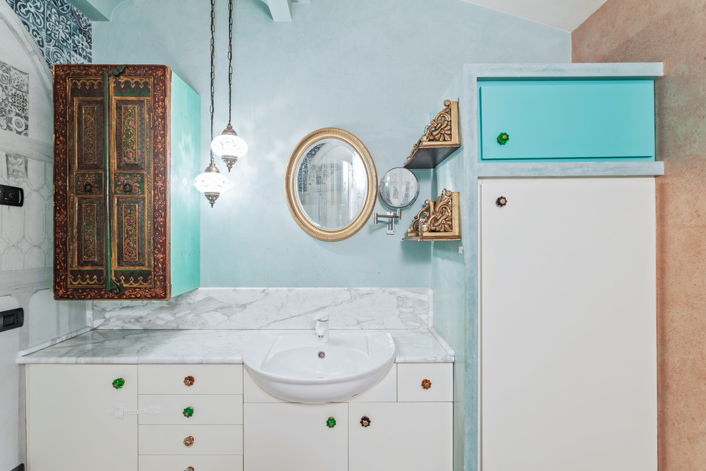 На фото: главная ванная комната среднего размера в восточном стиле с белыми фасадами, раздельным унитазом, синими стенами, полом из терраццо, накладной раковиной, мраморной столешницей, бежевым полом и серой столешницей