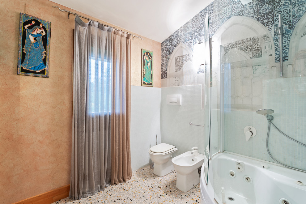 Foto di una stanza da bagno padronale etnica di medie dimensioni con vasca ad angolo, vasca/doccia, WC a due pezzi, pareti blu, pavimento alla veneziana, pavimento beige e porta doccia a battente