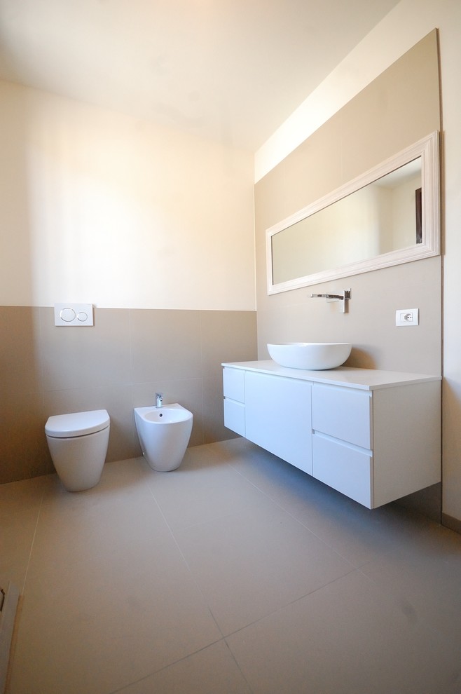 Idéer för funkis vitt badrum med dusch, med släta luckor, vita skåp, en bidé, ett fristående handfat, beige kakel, grå kakel, vita väggar och grått golv