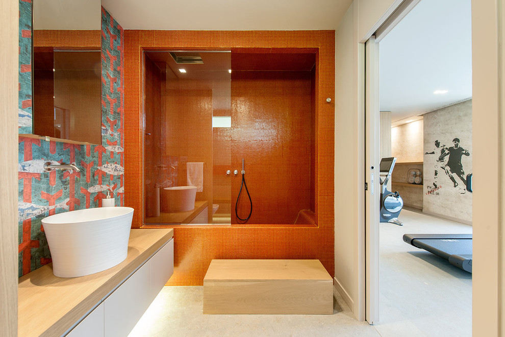 На фото: ванная комната в современном стиле с настольной раковиной, плоскими фасадами, белыми фасадами, ванной в нише, душем над ванной, оранжевой плиткой, плиткой мозаикой и бежевыми стенами с