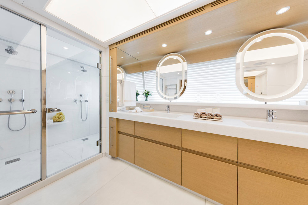 Imagen de cuarto de baño contemporáneo grande con armarios con paneles lisos, puertas de armario de madera clara y aseo y ducha