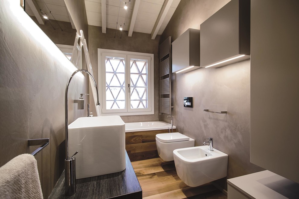 Foto di una stanza da bagno padronale contemporanea di medie dimensioni con ante lisce, ante beige, vasca da incasso, bidè, piastrelle beige, pareti beige, parquet chiaro, lavabo rettangolare e top in granito
