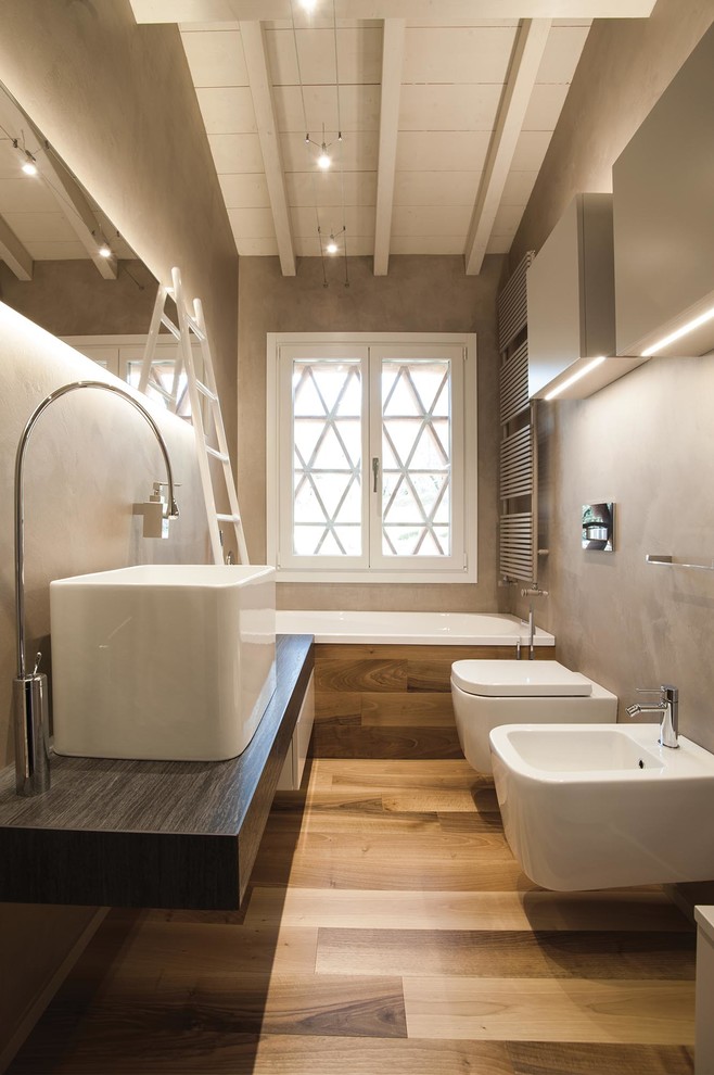 Inspiration for a small contemporary medium tone wood floor bathroom remodel in Florence with flat-panel cabinets, light wood cabinets, a wall-mount toilet, beige walls, a trough sink and quartzite countertops
