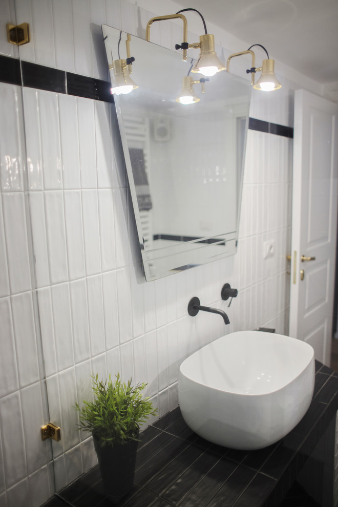 Modelo de cuarto de baño minimalista pequeño con puertas de armario negras, aseo y ducha, encimera de azulejos y encimeras negras