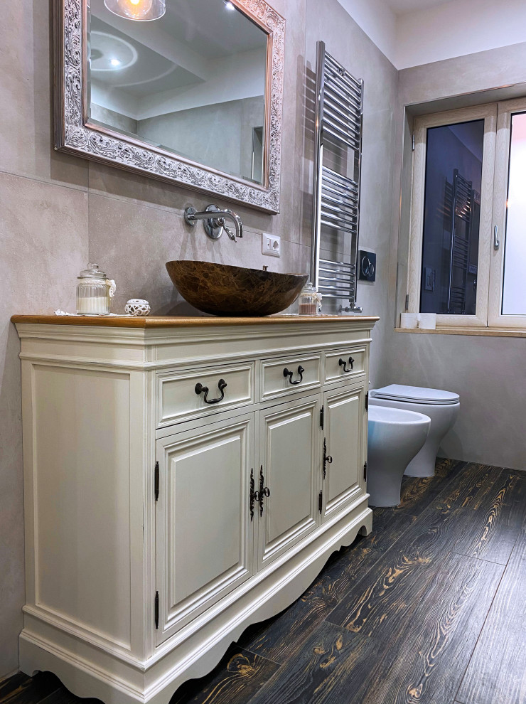 Inredning av ett shabby chic-inspirerat litet beige beige en-suite badrum, med luckor med upphöjd panel, vita skåp, ett platsbyggt badkar, en kantlös dusch, en toalettstol med separat cisternkåpa, grå kakel, porslinskakel, vita väggar, ett fristående handfat, träbänkskiva, brunt golv och dusch med skjutdörr