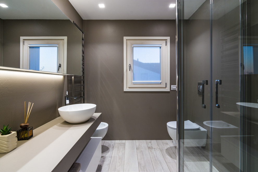 Photo of a contemporary shower room bathroom in Milan with flat-panel cabinets, white cabinets, a corner shower, a two-piece toilet, grey walls, porcelain flooring, an integrated sink, white floors and a hinged door.