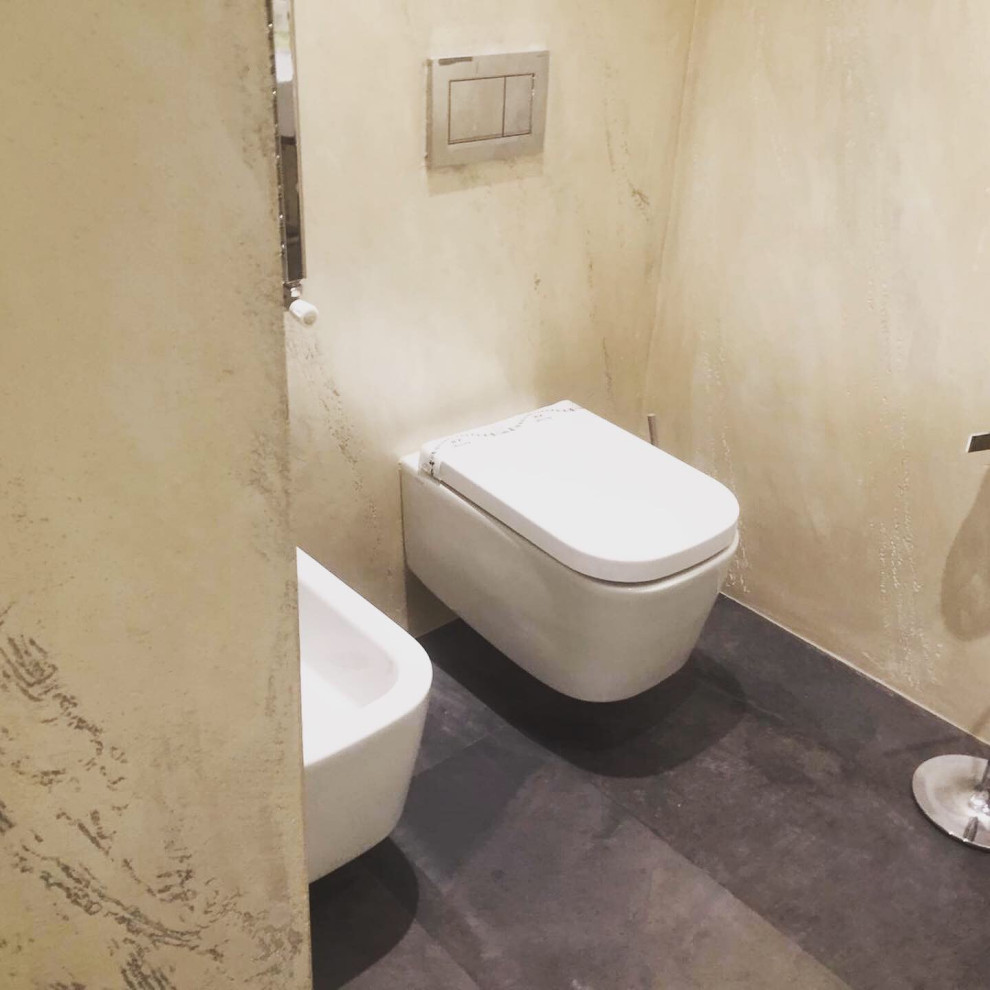 Aménagement d'un WC suspendu moderne de taille moyenne avec un plan de toilette en surface solide, un sol gris et un plan de toilette multicolore.