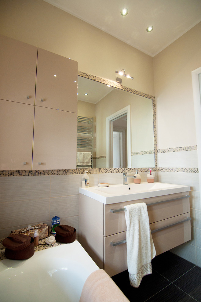 Cette photo montre une petite salle de bain moderne avec un placard à porte plane, des portes de placard beiges, une baignoire en alcôve, WC séparés, un carrelage beige, des carreaux de céramique, un mur beige, un sol en carrelage de céramique, un plan vasque et un plan de toilette en marbre.