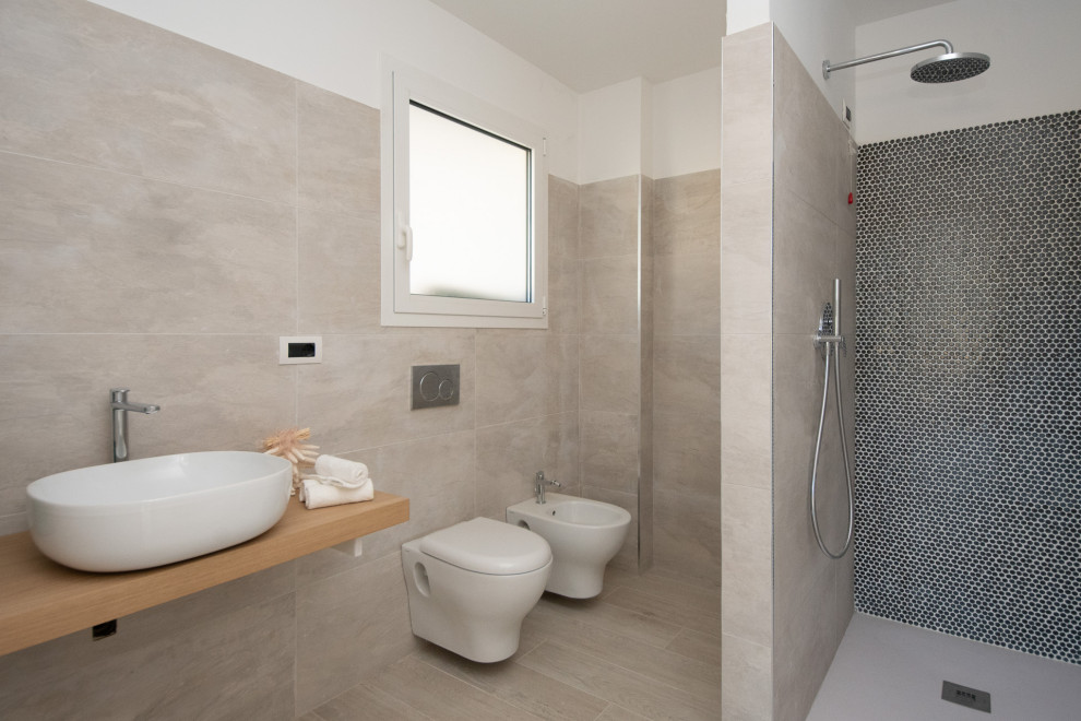 This is an example of a medium sized contemporary shower room bathroom in Other with open cabinets, a built-in shower, a wall mounted toilet, beige tiles, a vessel sink, porcelain tiles, white walls, porcelain flooring, wooden worktops, beige floors and beige worktops.