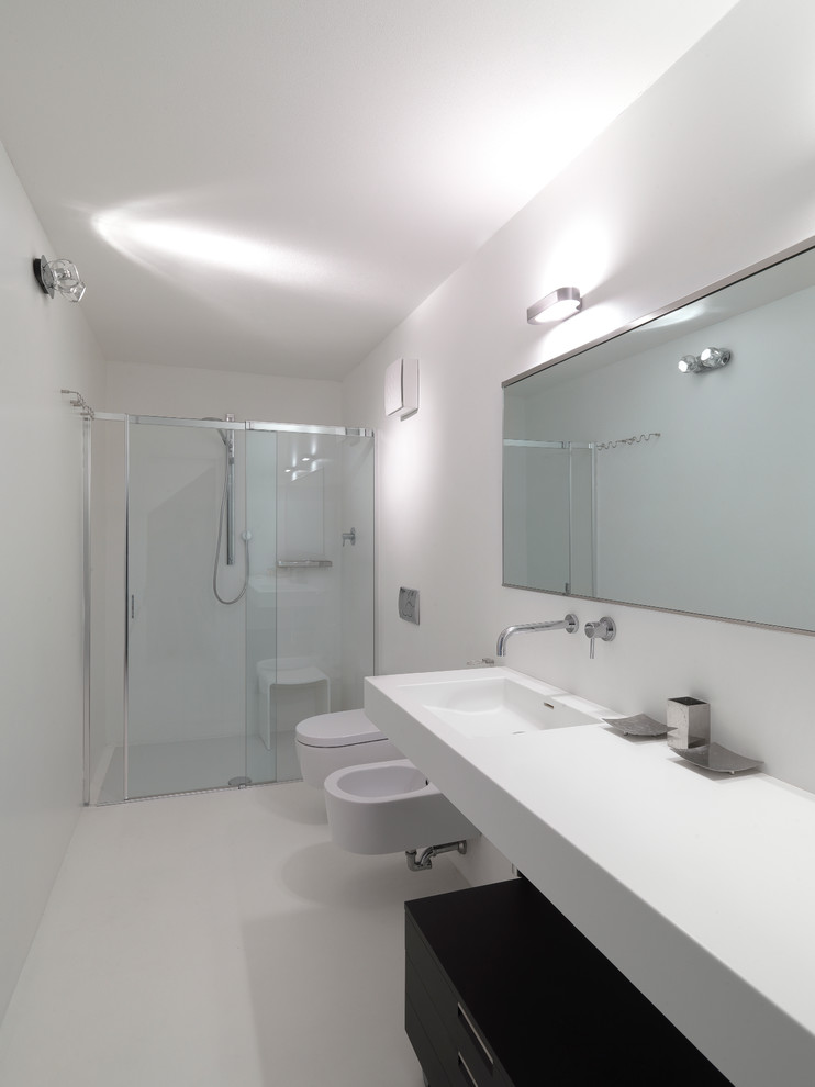 Foto de cuarto de baño actual con paredes blancas, ducha empotrada, aseo y ducha y lavabo integrado