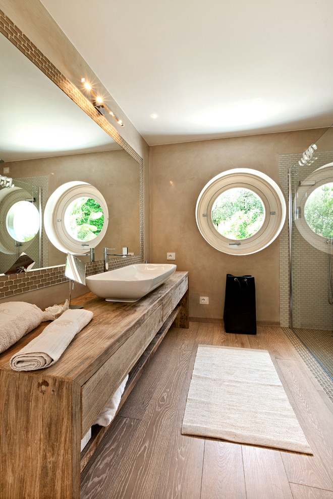 Стильный дизайн: ванная комната в современном стиле с настольной раковиной, искусственно-состаренными фасадами, бежевой плиткой, паркетным полом среднего тона, столешницей из дерева, плоскими фасадами и коричневой столешницей - последний тренд