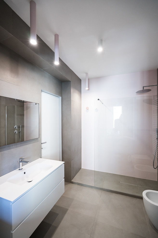 Modernes Duschbad mit flächenbündigen Schrankfronten, weißen Schränken, grauen Fliesen, integriertem Waschbecken, grauem Boden, weißer Waschtischplatte, Eckdusche, rosa Wandfarbe und offener Dusche in Rom