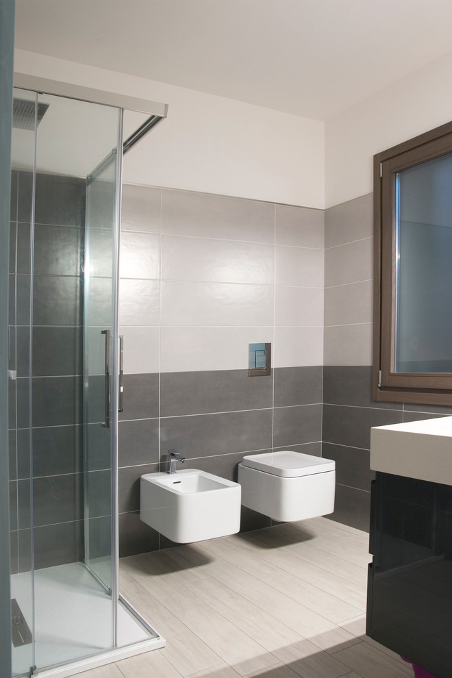 Exemple d'une petite salle d'eau tendance avec des portes de placard blanches, une douche à l'italienne, WC suspendus, un carrelage beige, des carreaux de céramique, un mur gris, un sol en carrelage de céramique et une grande vasque.