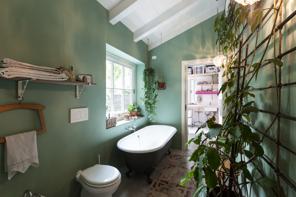 Modelo de cuarto de baño principal campestre con bañera con patas, sanitario de una pieza y paredes verdes