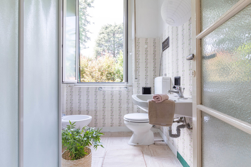 Foto di una stanza da bagno tradizionale con bidè, piastrelle beige, pareti beige, lavabo sospeso e pavimento beige