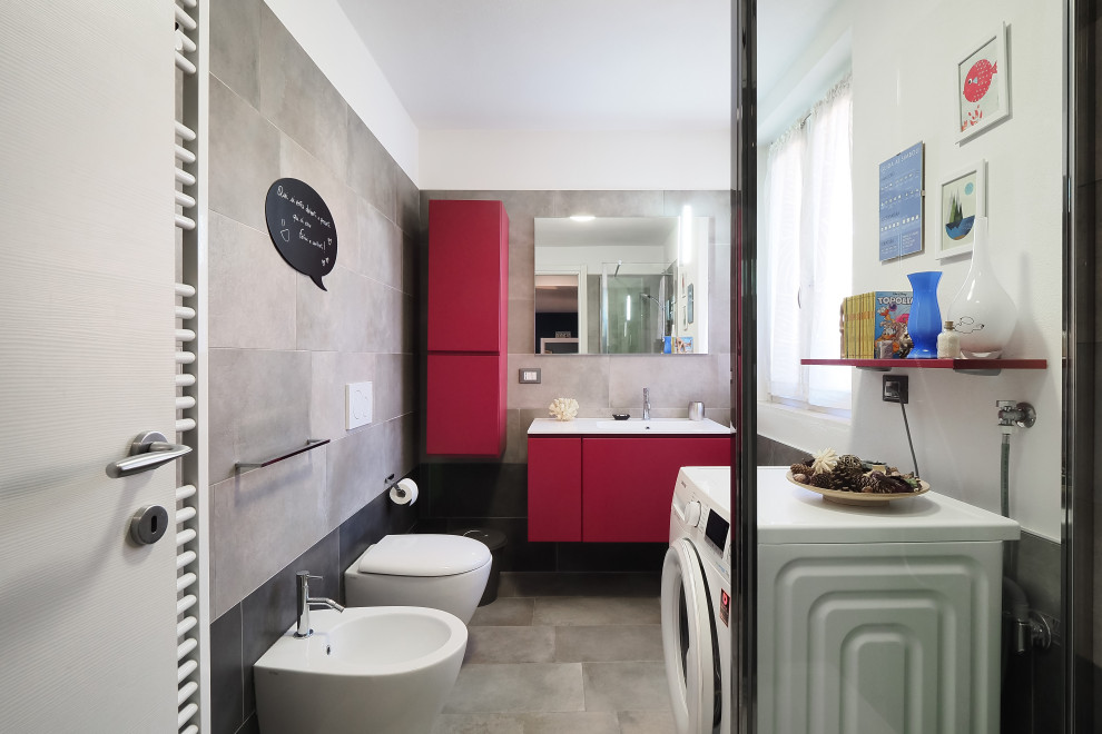 Idee per una stanza da bagno con doccia design di medie dimensioni con ante lisce, ante rosse, WC sospeso, piastrelle grigie, piastrelle in gres porcellanato, pareti bianche, pavimento in gres porcellanato, lavabo integrato, pavimento grigio e top bianco