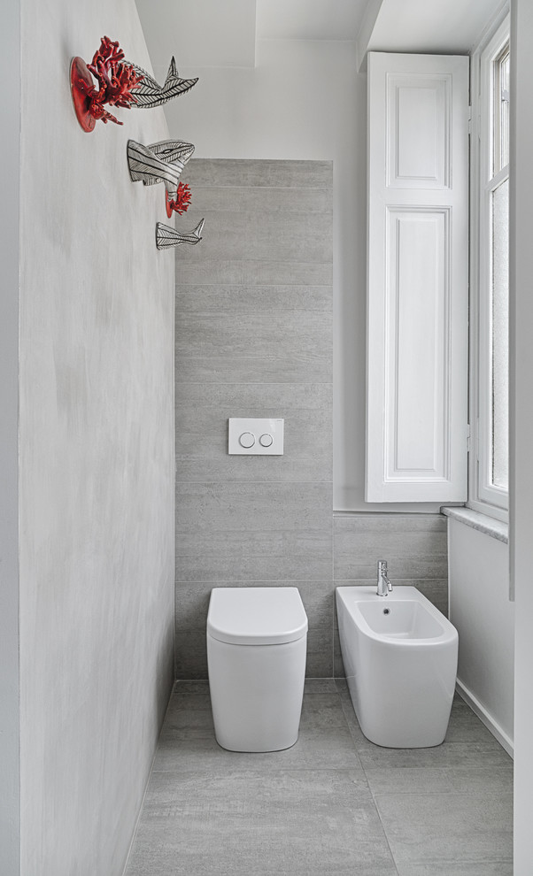 Cette photo montre une petite salle de bain principale et grise et blanche tendance avec un combiné douche/baignoire, un bidet, un carrelage gris, des carreaux de céramique et un mur blanc.