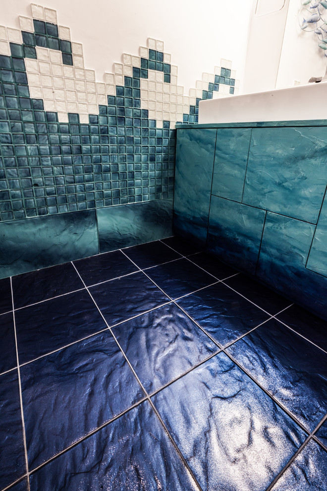 Идея дизайна: ванная комната в современном стиле с плоскими фасадами, бирюзовыми фасадами, инсталляцией, синей плиткой, стеклянной плиткой, разноцветными стенами, полом из керамической плитки, душевой кабиной, раковиной с несколькими смесителями, синим полом и душем с раздвижными дверями