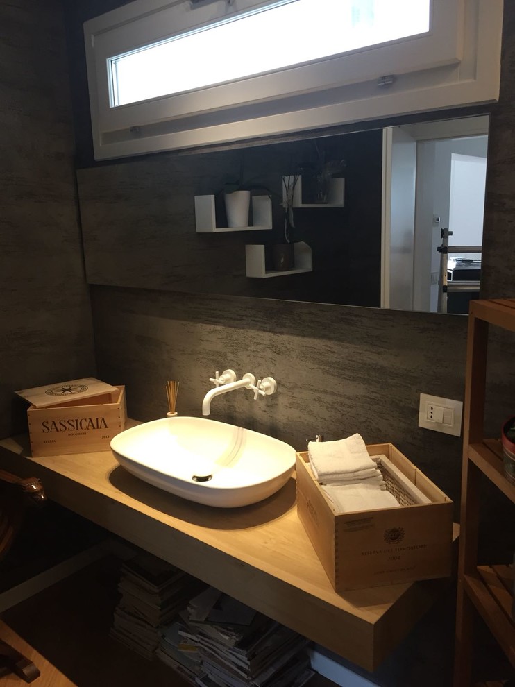 Immagine di una piccola stanza da bagno con doccia minimal con nessun'anta, ante in legno chiaro, piastrelle grigie, pareti nere, pavimento in legno massello medio, lavabo a bacinella e top in legno