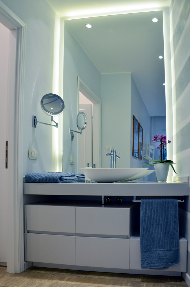 Идея дизайна: главная ванная комната среднего размера в стиле модернизм с плоскими фасадами, светлыми деревянными фасадами, угловой ванной, инсталляцией, серой плиткой, серыми стенами, светлым паркетным полом, настольной раковиной и столешницей из искусственного кварца