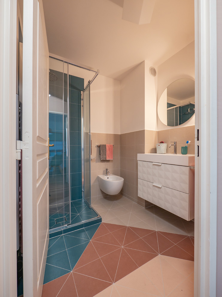 На фото: маленькая ванная комната в современном стиле с фасадами с выступающей филенкой, белыми фасадами, угловым душем, раздельным унитазом, разноцветной плиткой, керамогранитной плиткой, белыми стенами, полом из керамогранита, душевой кабиной, консольной раковиной, столешницей из искусственного камня, разноцветным полом, душем с раздвижными дверями и белой столешницей для на участке и в саду с
