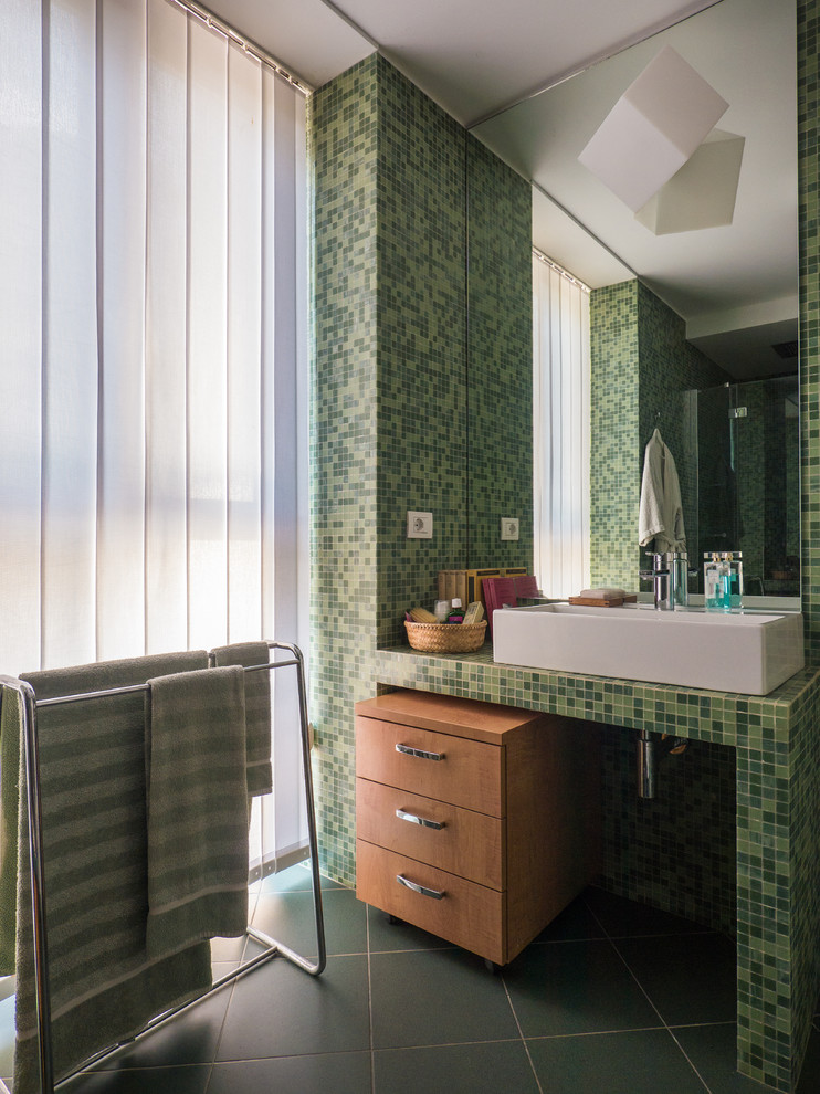 Стильный дизайн: маленькая главная ванная комната в современном стиле с плоскими фасадами, светлыми деревянными фасадами, душем в нише, раздельным унитазом, зеленой плиткой, плиткой мозаикой, зелеными стенами, полом из керамической плитки, раковиной с несколькими смесителями, столешницей из плитки, зеленым полом, душем с распашными дверями и зеленой столешницей для на участке и в саду - последний тренд