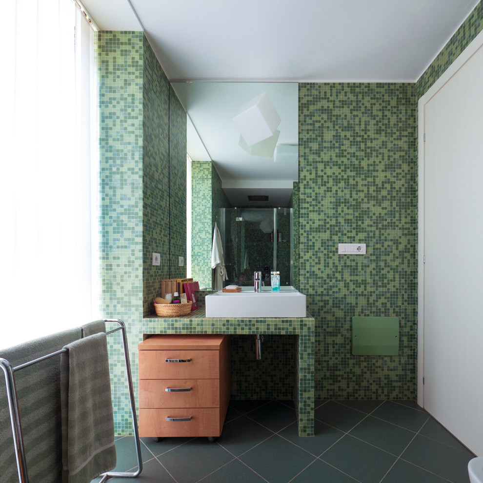 Aménagement d'une petite douche en alcôve principale contemporaine en bois clair avec un placard à porte plane, WC séparés, un carrelage vert, mosaïque, un mur vert, un sol en carrelage de céramique, une grande vasque, un plan de toilette en carrelage, un sol vert, une cabine de douche à porte battante et un plan de toilette vert.
