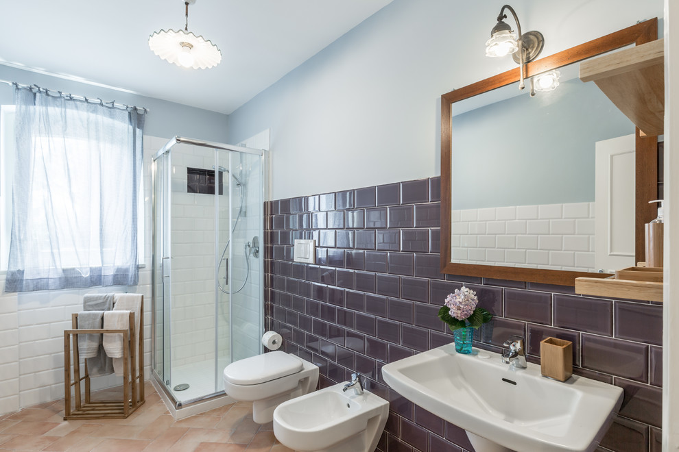 На фото: ванная комната среднего размера в стиле кантри с угловым душем, инсталляцией, коричневой плиткой, керамической плиткой, полом из терракотовой плитки, подвесной раковиной и душем с раздвижными дверями с