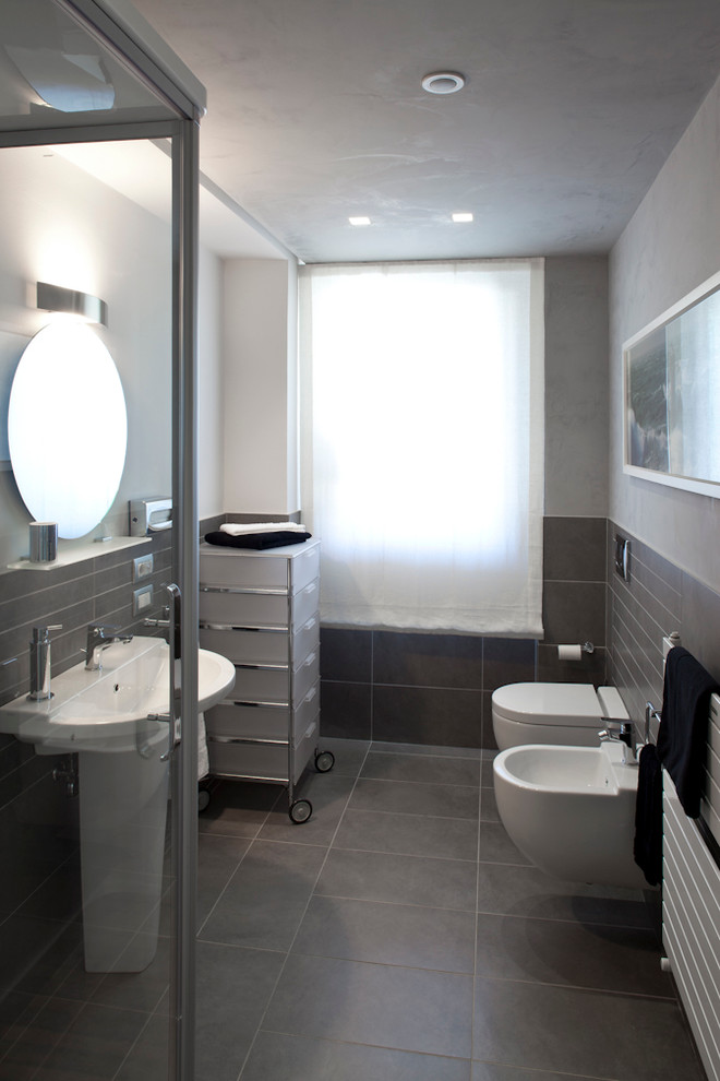 Foto di una stanza da bagno minimal con WC sospeso, piastrelle grigie, piastrelle in ceramica, pareti bianche e lavabo a colonna