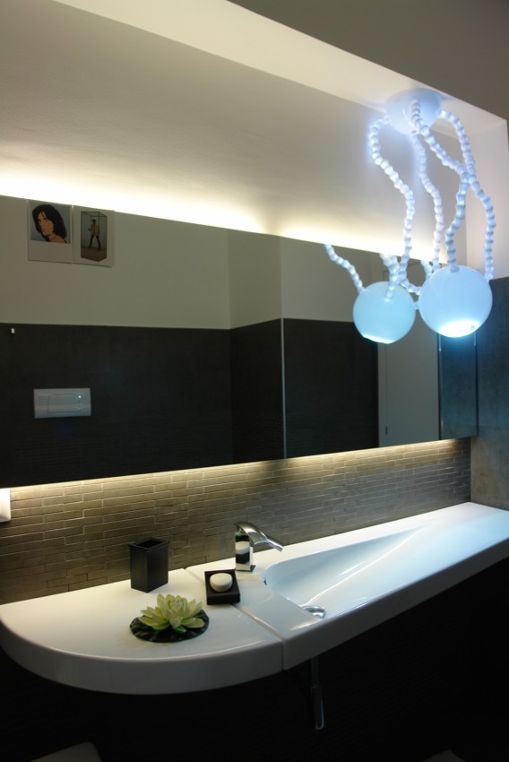 Cette photo montre une petite salle de bain principale tendance avec un bain bouillonnant, WC séparés, des carreaux de porcelaine, un sol en carrelage de porcelaine, un lavabo suspendu, un placard sans porte, un carrelage gris, un mur gris et un sol gris.