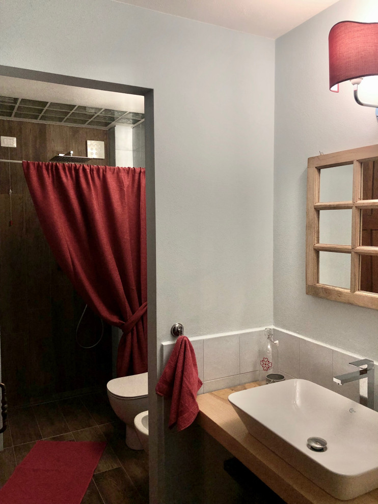 Immagine di una piccola stanza da bagno con doccia industriale con doccia a filo pavimento, WC a due pezzi, piastrelle in ceramica, lavabo a bacinella, top in legno e un lavabo