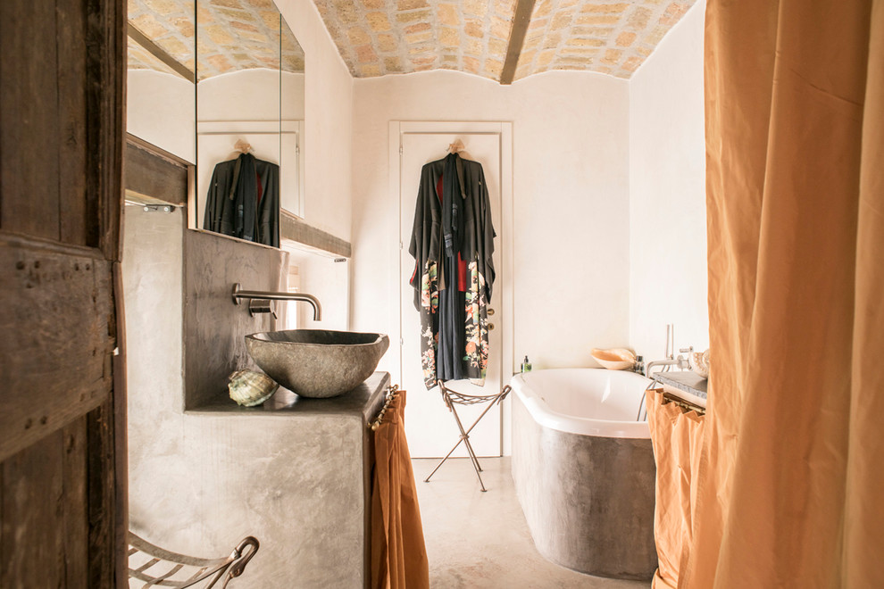 Imagen de cuarto de baño de estilo de casa de campo con bañera encastrada, suelo de cemento, aseo y ducha, lavabo sobreencimera y encimera de cemento