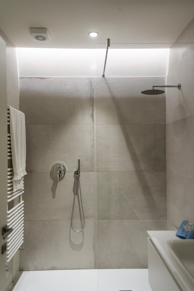 Пример оригинального дизайна: ванная комната в современном стиле с белыми фасадами, душем без бортиков, белой плиткой, душевой кабиной, накладной раковиной и душем с раздвижными дверями