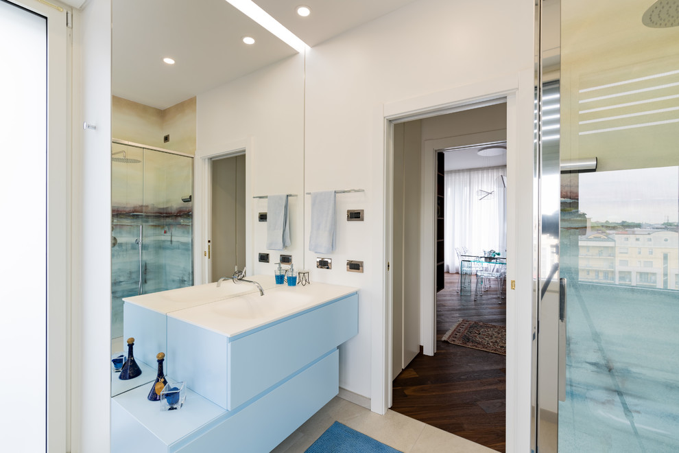 Example of a large trendy 3/4 multicolored tile and porcelain tile porcelain tile and gray floor bathroom design in Milan with turquoise cabinets, a two-piece toilet, white walls, an integrated sink, quartz countertops and white countertops