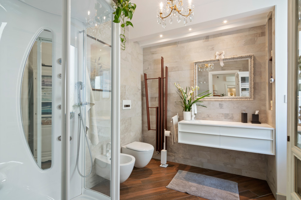 Inredning av ett modernt litet vit vitt badrum med dusch, med luckor med infälld panel, vita skåp, en hörndusch, en vägghängd toalettstol, flerfärgad kakel, porslinskakel, vita väggar, klinkergolv i porslin, ett integrerad handfat, bänkskiva i akrylsten, brunt golv och dusch med skjutdörr
