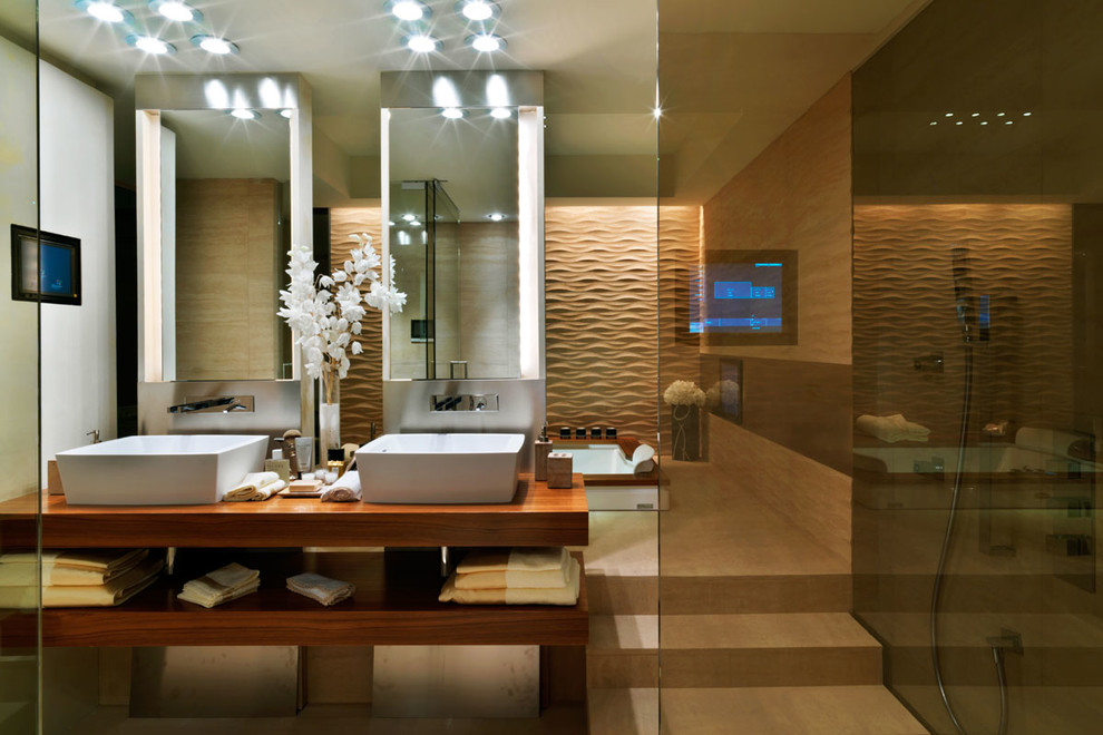 Inredning av ett modernt en-suite badrum, med öppna hyllor, bruna skåp, ett platsbyggt badkar, en öppen dusch, beige kakel, beige väggar, ett fristående handfat, träbänkskiva, beiget golv och med dusch som är öppen