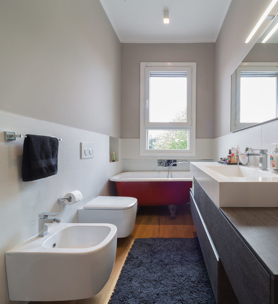 Small contemporary ensuite bathroom in Milan with flat-panel cabinets, black cabinets, a claw-foot bath, a shower/bath combination, a bidet, white tiles, ceramic tiles, beige walls, an open shower, medium hardwood flooring, an integrated sink, wooden worktops, beige floors and brown worktops.