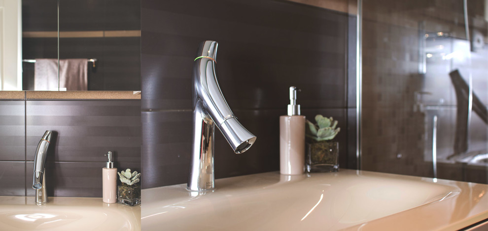 Foto på ett mellanstort funkis badrum med dusch, med släta luckor, bruna skåp, en kantlös dusch, brun kakel, porslinskakel, bruna väggar, ett integrerad handfat och bänkskiva i glas