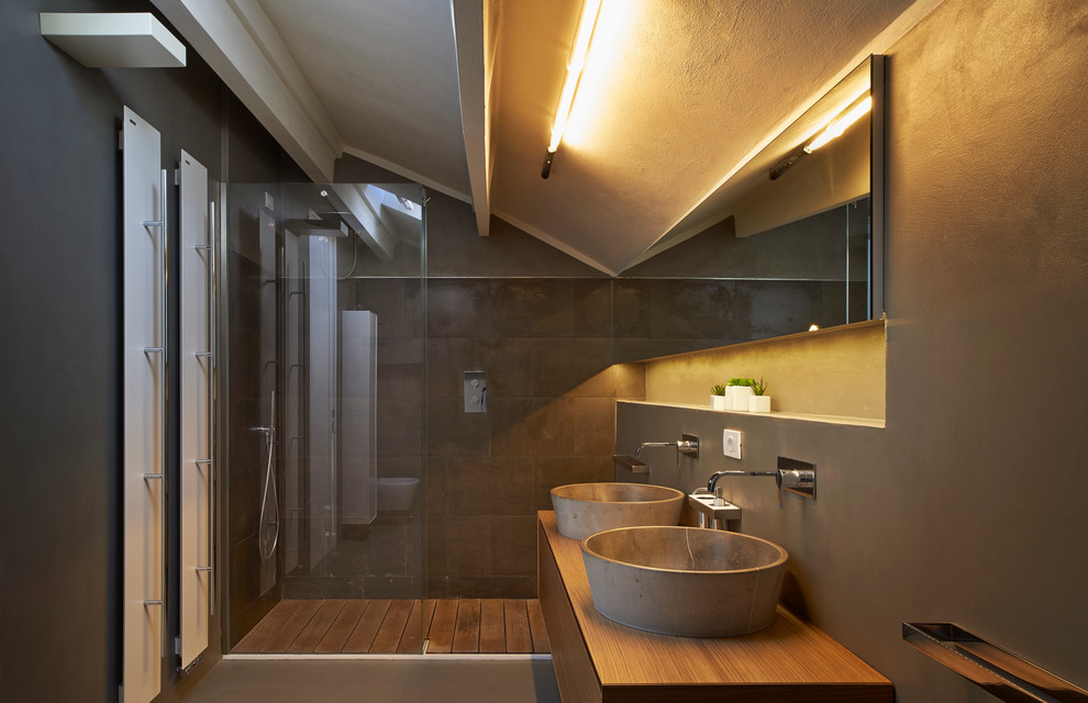 На фото: ванная комната в современном стиле с плоскими фасадами, фасадами цвета дерева среднего тона, душем в нише, серыми стенами, душевой кабиной, настольной раковиной, столешницей из дерева и коричневой столешницей