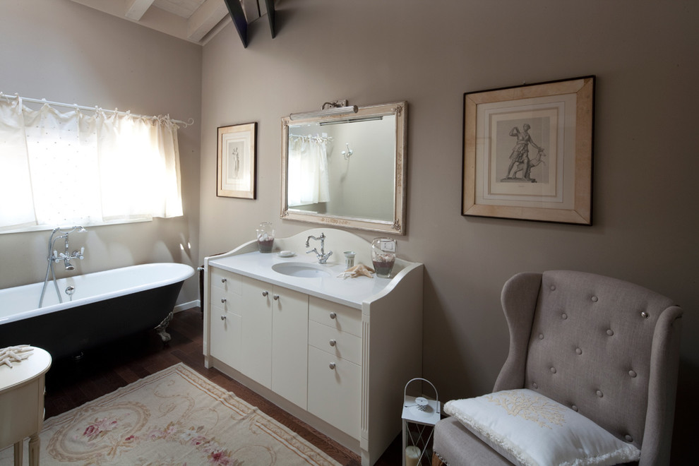 Ispirazione per una stanza da bagno padronale minimal con vasca con piedi a zampa di leone, parquet scuro e lavabo da incasso