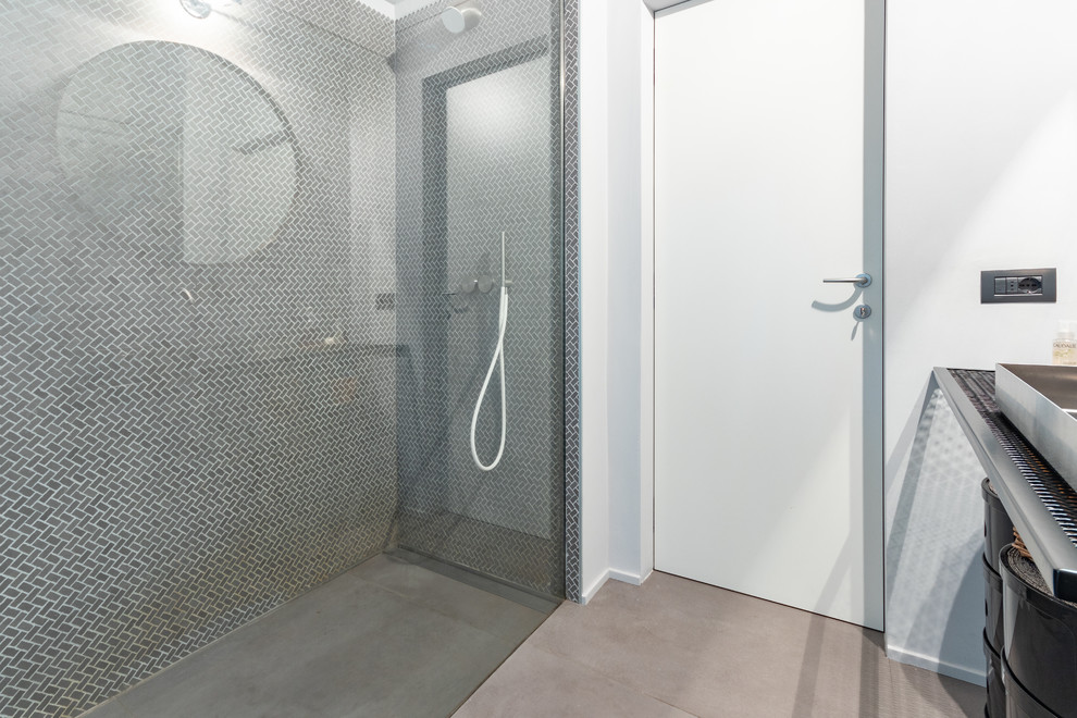 Exemple d'une grande salle de bain principale industrielle avec une douche à l'italienne, WC séparés, un carrelage gris, des carreaux de porcelaine, un mur gris, un sol en carrelage de porcelaine, une vasque, un plan de toilette en acier inoxydable, un sol gris, aucune cabine et un plan de toilette noir.