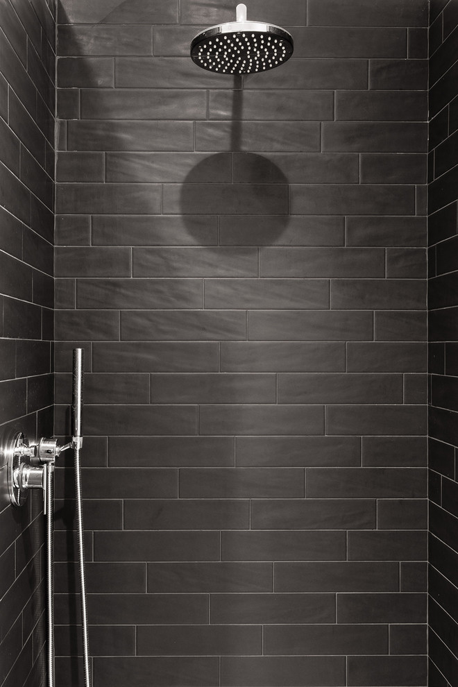 Inredning av ett industriellt litet badrum med dusch, med en kantlös dusch, svart kakel, porslinskakel, vita väggar och ett fristående handfat