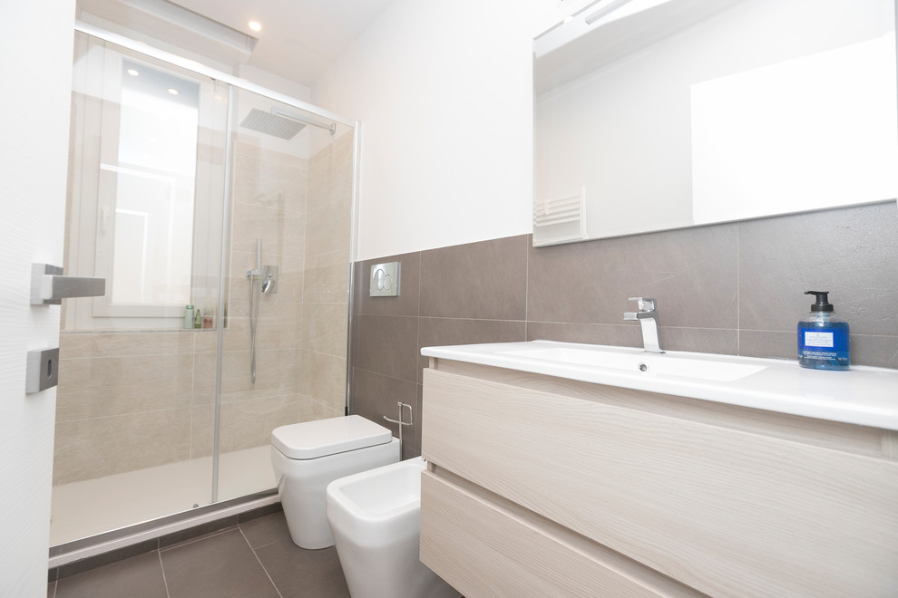Inspiration for a medium sized contemporary shower room bathroom in Other with freestanding cabinets, beige cabinets, a walk-in shower, brown tiles, porcelain tiles, white walls, porcelain flooring, a built-in sink, solid surface worktops, brown floors and a sliding door.
