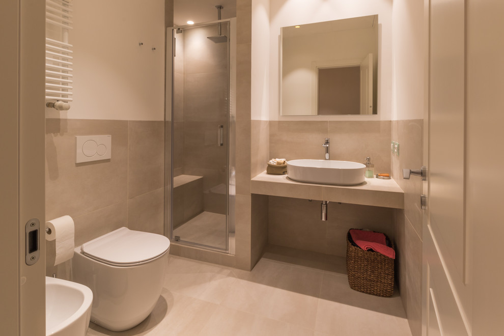 Design ideas for a small contemporary family bathroom in Milan with a built-in shower, a two-piece toilet, beige tiles, porcelain tiles, white walls, porcelain flooring, a vessel sink, tiled worktops, beige floors and a hinged door.