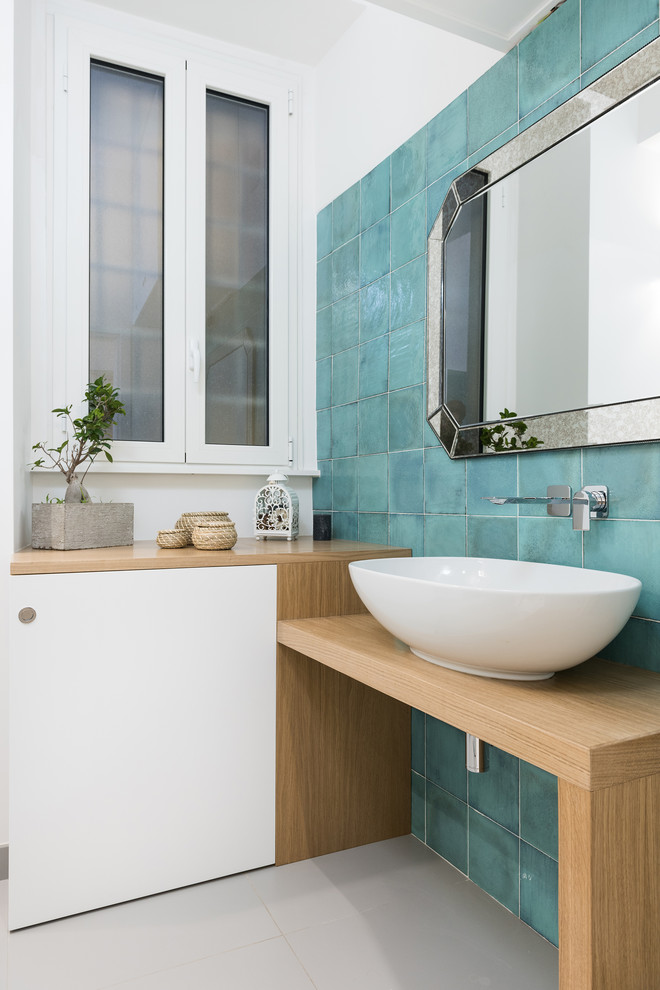 Esempio di una stanza da bagno con doccia minimal di medie dimensioni con ante lisce, ante in legno chiaro, bidè, pareti blu, lavabo a bacinella, top in legno, pavimento grigio, piastrelle blu e top beige