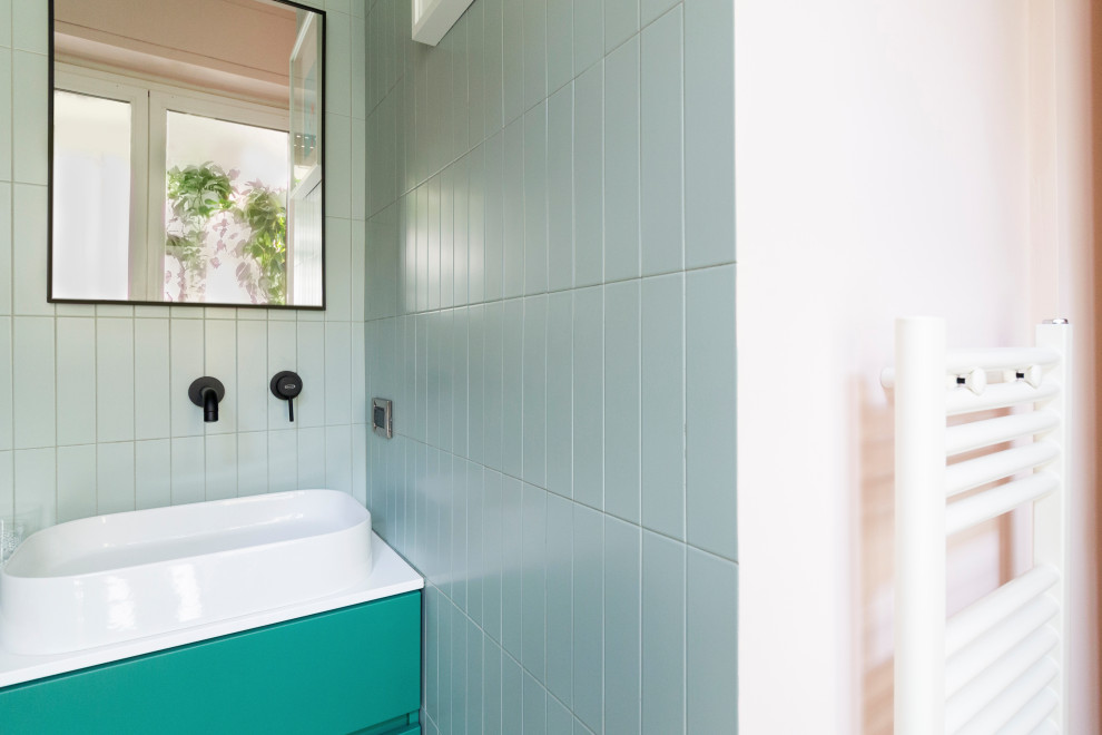 Идея дизайна: маленькая ванная комната в стиле модернизм с плоскими фасадами, зелеными фасадами, угловым душем, инсталляцией, зеленой плиткой, керамической плиткой, розовыми стенами, полом из керамогранита, душевой кабиной, настольной раковиной, столешницей из ламината, серым полом, душем с раздвижными дверями, белой столешницей, нишей, тумбой под одну раковину, напольной тумбой и панелями на части стены для на участке и в саду