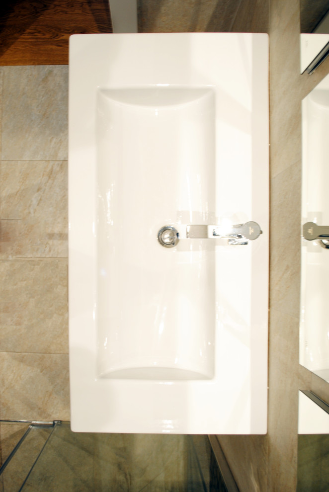 Immagine di una stanza da bagno con doccia minimalista con ante in legno bruno, doccia a filo pavimento, WC sospeso, piastrelle beige, piastrelle in gres porcellanato, pareti beige, pavimento in gres porcellanato, lavabo da incasso, pavimento beige e porta doccia scorrevole