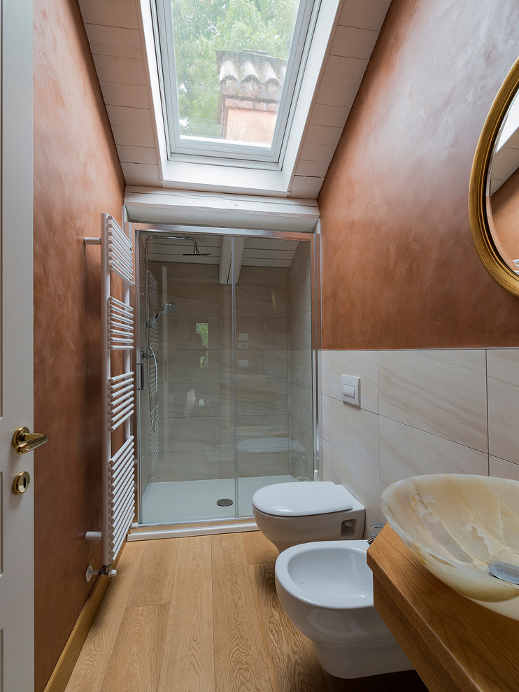 Imagen de cuarto de baño romántico de tamaño medio con ducha doble, sanitario de pared, parades naranjas y suelo de madera en tonos medios