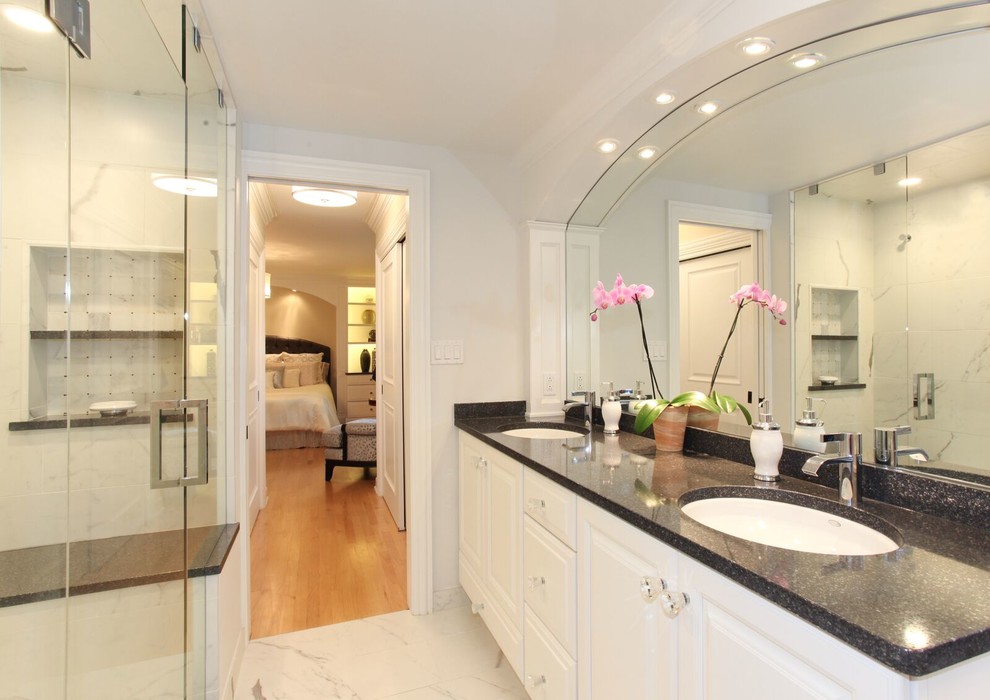 Photo of a medium sized traditional ensuite bathroom in Chicago with raised-panel cabinets, white cabinets, stone tiles, granite worktops, a freestanding bath, an alcove shower, a submerged sink, a two-piece toilet, white walls and marble flooring.